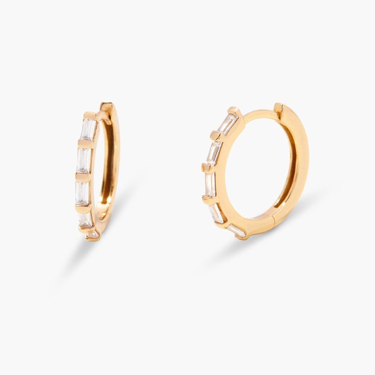 Discover effortless elegance with Elliana Hoops. Crafted from 14k gold, these hoops add the perfect touch of sparkle to any look. Feel confident and beautiful with these timeless earrings - are you ready to shine? Available in 14k gold plated sterling silver Hoop size: 5/8" Hoop width: 1mm Baguette CZ: 1.5mmx3mm Hinged closure Protected with an anti-tarnish barrier SKU: BYE1137 Modern Gold Hoop Earrings With Prong Setting, 14k Gold Small Hoop Jewelry With Halo Design, Vvs Clarity Gold Hoop Diamond Earrings, Gold Hoop Diamond Earrings With Vvs Clarity, Gold Vvs Clarity Diamond Hoop Earrings, Timeless Gold Huggie Earrings With Prong Setting, Gold Plated Hoop Earrings With Prong Setting, Anniversary Gold Plated Hoop Earrings With Prong Setting, Timeless 14k Gold Hypoallergenic Hoop Earrings