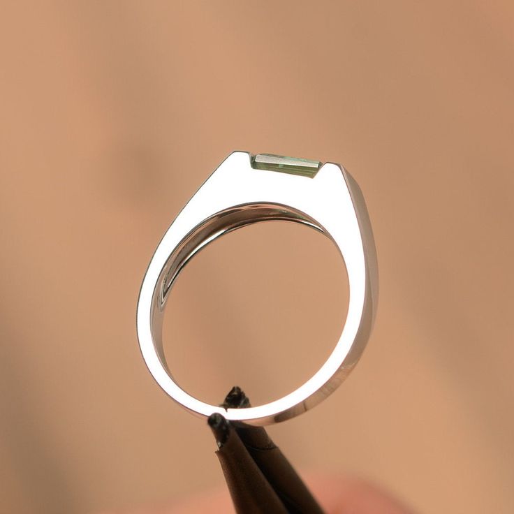 It is a green sapphire ring. The main stone is 5 mm*7 mm emerald cut.weight about 1.20 carats. The basic metal is sterling silver and plated with rhodium/14k white gold/14k rose gold/14k yellow gold You can also go to my shop Home for more elegant rings: https://www.etsy.com/shop/godjewelry?ref=hdr_shop_menu Customization is always welcome and please feel free to contact with me if you have any design ideas! Modern Emerald Cut May Birthstone Jewelry, Modern Asscher Cut Emerald Promise Ring, Minimalist Emerald Cut Green Jewelry, Modern Sterling Silver Emerald Cut Sapphire Ring, Modern Green Emerald-cut Jewelry, Modern Emerald Ring With Baguette Cut And Prong Setting, Modern Emerald Ring With Baguette Cut, Modern Baguette Cut Emerald Ring For May Birthstone, Modern White Gold Emerald Ring With Baguette Cut