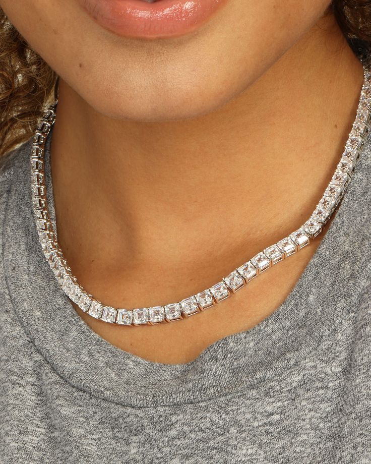 We LOVE our simulated diamonds. Easy and classy to put on and layer for a chic look. We are obsessed with how these give you regal elegance and make you feel like a Queen. These are the next staples you need in your jewelry collection. DETAILS: Tennis Necklace Length: 16" 71 stones Box Push Clasp SKU: N6013 MATERIALS: Silver Plated Over Brass Stone: 5x5mm Simulated Diamonds Formal Cubic Zirconia Diamond Necklace With Baguette Cut, Silver Baguette Cut Classic Tennis Necklace, Classic Silver Baguette Cut Tennis Necklace, Diamond White Baguette Cut Diamond Necklace, Everyday Luxury Diamond White Lab Grown Diamond Jewelry, Everyday Luxury Lab Grown Diamond White Jewelry, Glamorous Cubic Zirconia Bridal Necklace With Diamond Accents, Luxury Silver Tennis Necklace With Lab Grown Diamonds, Glamorous Diamond White Diamond Necklace