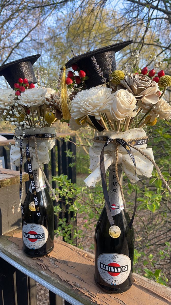 two bottles with flowers in them sitting on a balcony