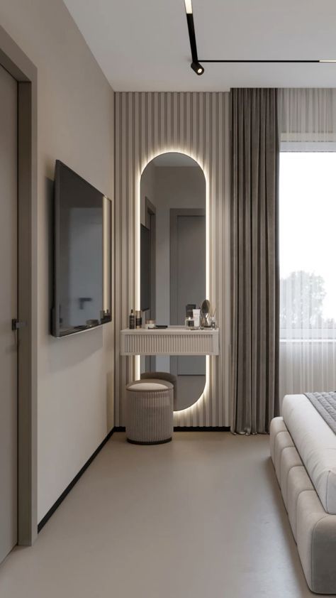 a bedroom with a bed, mirror and television on the wall next to a window