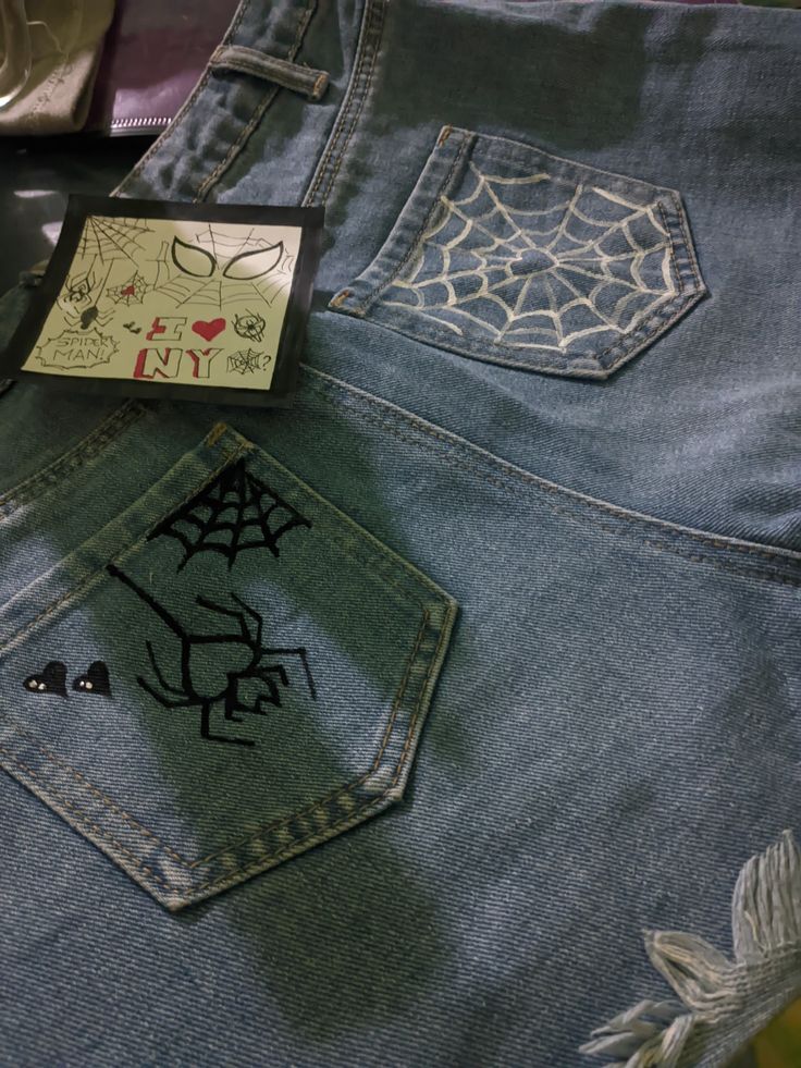 a pair of jeans with spider webs on them and a tag attached to the back