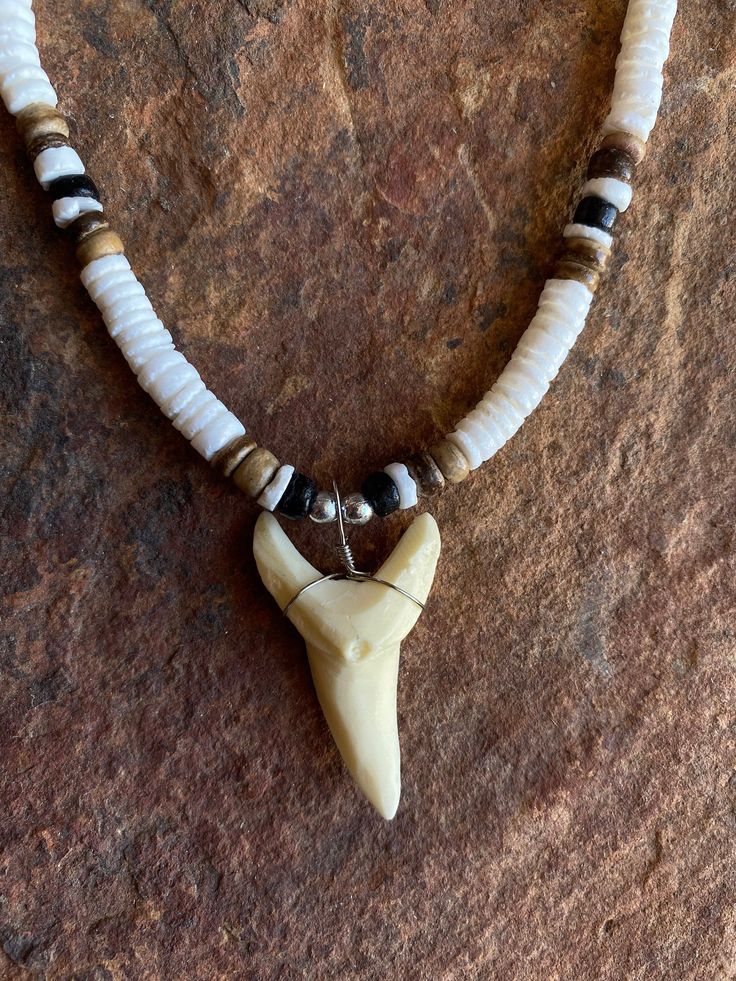 Necklace Length:  Approx. 18 inches Bone Powder Shark Tooth Length: Approx. 1.5 inches Each piece has a distinct character of its own, for no two are exactly alike in color, shape, and size. Hand-crafted, sanded and polished by Native artisans Sharks Tooth Jewelry, Nickel-free White Necklace With Round Beads, Craft For School, Shark Teeth Jewelry, Hawaii Design, Arrowheads Design, Tooth Jewelry, Shark Stuff, Hawaiian Necklace