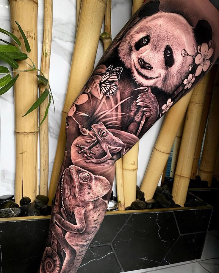 a panda bear and other animals are depicted on this leg sleeve tattoo, which features bamboo stalks