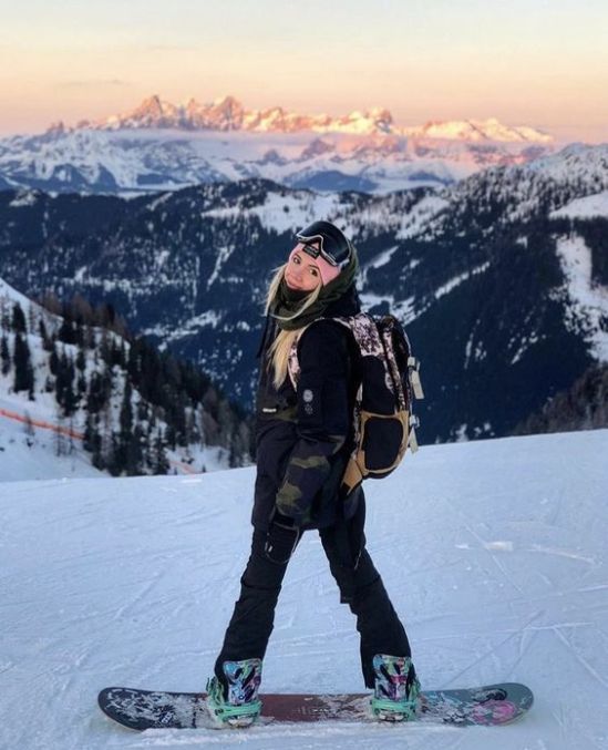 a woman standing on top of a snow covered slope