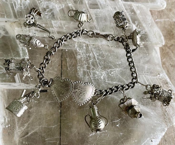 FREE SHIPPING to all US addresses!  This listing is for a vintage signed "Vargas" 1930's-40's sterling silver novelty charm bracelet. It is signed 'Vargas Sterling" on the central hearts. There are 6 articulated charms with moving parts--2 lanterns, fish, carriage, brazier and turtle. Also 4 other rigid charms. The central double hearts are engraved "Shirley" and "K. Roy". I believe this was a carnival State Fair prize. I love that the turtle's head and feet all move. All of the charms and the b Vintage Collectible Charm Bracelet, Vintage Engraved Charm Bracelet, Vintage Handmade Charm Bracelet Collectible, Handmade Vintage Charm Bracelet Collectible, Vintage Handmade Collectible Charm Bracelet, Vintage Silver Charm Bracelet For Wedding, Vintage Heart-shaped Bracelets With Charm, Heart Shaped Vintage Bracelets With Vintage Charm, Vintage Heart-shaped Bracelet With Charm