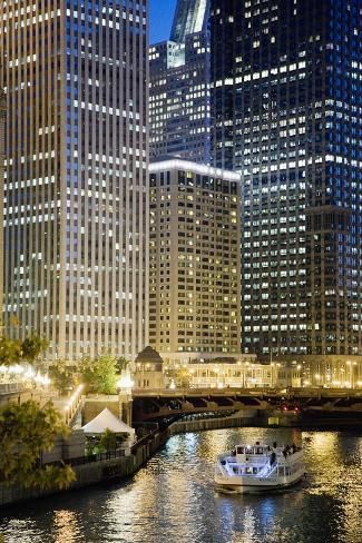 a boat is floating down the river in front of some tall buildings at night time