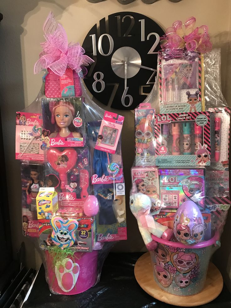 two barbie dolls are sitting next to each other in front of a wall clock and some toys