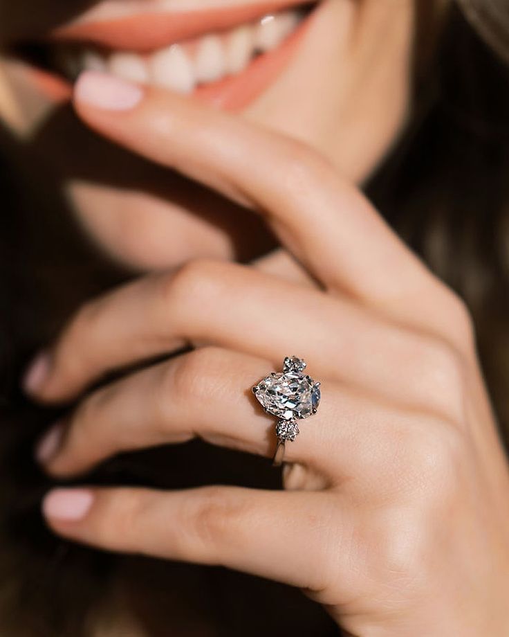 a close up of a person wearing a diamond ring