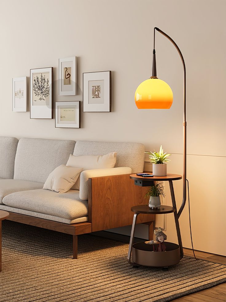 a living room with a couch, lamp and pictures on the wall