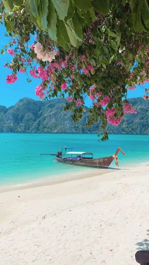 a boat that is sitting in the sand near the water and some people on it