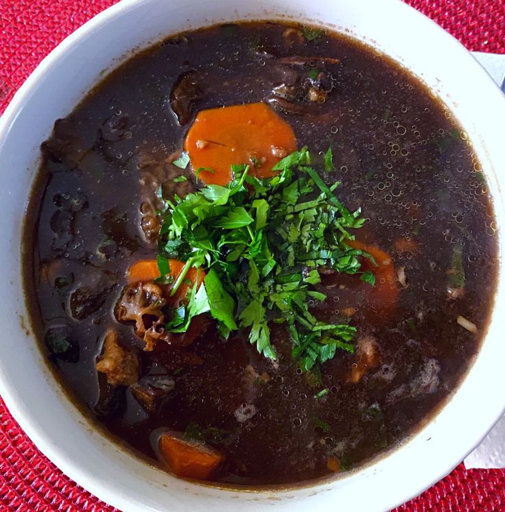 a white bowl filled with soup on top of a red table