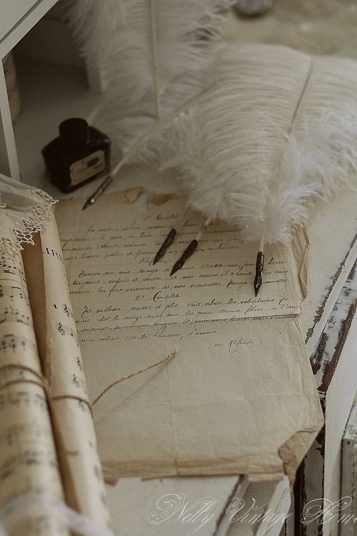 an old book with writing on it sitting next to a feather pen and inkwell