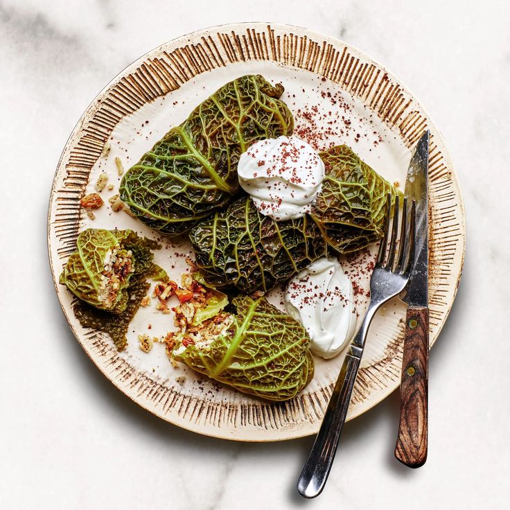 a white plate topped with lettuce covered in cream