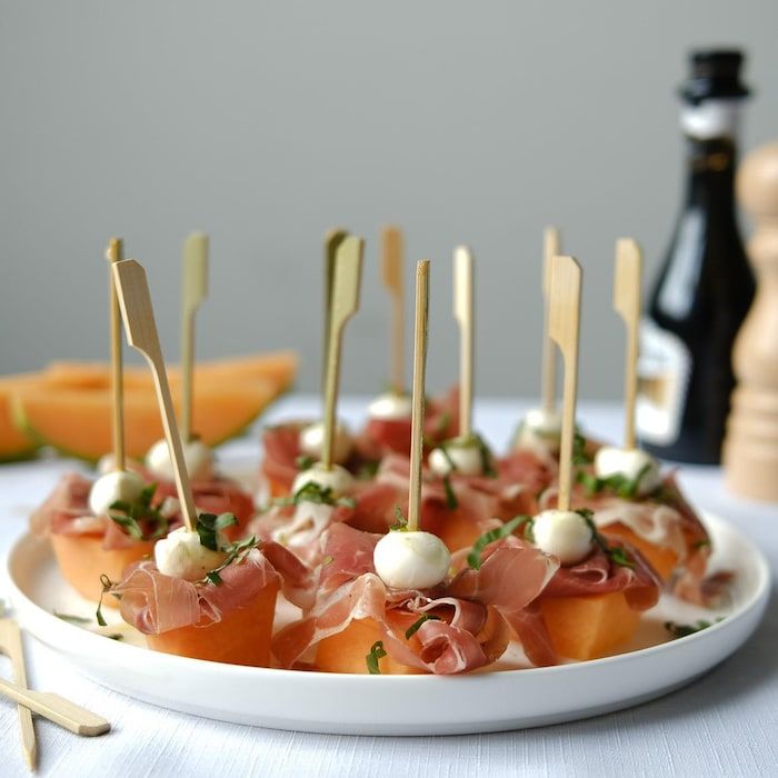 small appetizers are arranged on a plate with toothpicks