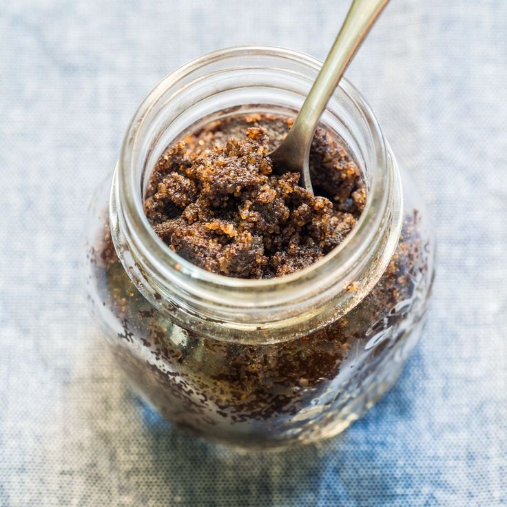 a spoon is sticking out of a jar filled with brown stuff on a blue table cloth