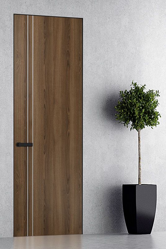 a potted plant sitting next to a wooden door in a white room with grey walls