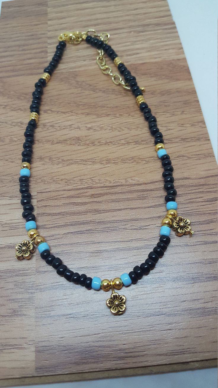 "Black & Blue Boho Daisy Choker Boho Daisy Choker made with black and blue seeds beads, accented with gold metal spacer beads. Boho jewelry is trending jewelry for the young and the young at heart! This Black choker will complement so many outfits and makes nice summer jewelry and festival jewelry. This boho beaded necklace would make a nice jewelry gift for you or a friend. The choker is 13 1/2\" long with a 3\" extension chain to insure a perfect fit and comfort of wear. The necklace has d Bohemian Black Beaded Bracelets With Gold Beads, Black Beaded Bracelets With Heart Beads For Jewelry Making, Black Beads With Gold Details For Festival, Black And Gold Beads For Festival, Blue Beaded Bracelet With Black Beads For Festival, Black Jewelry With Gold Beads For Festivals, Black Beaded Necklaces With Gold Beads For Festival, Black Spacer Beads For Festival, Adjustable Black Beaded Necklace With Heart Beads