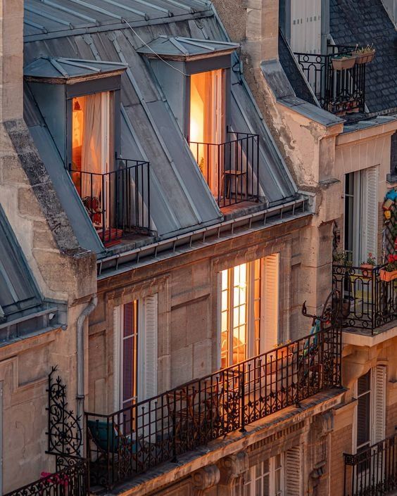 an apartment building with two balconies at sunset