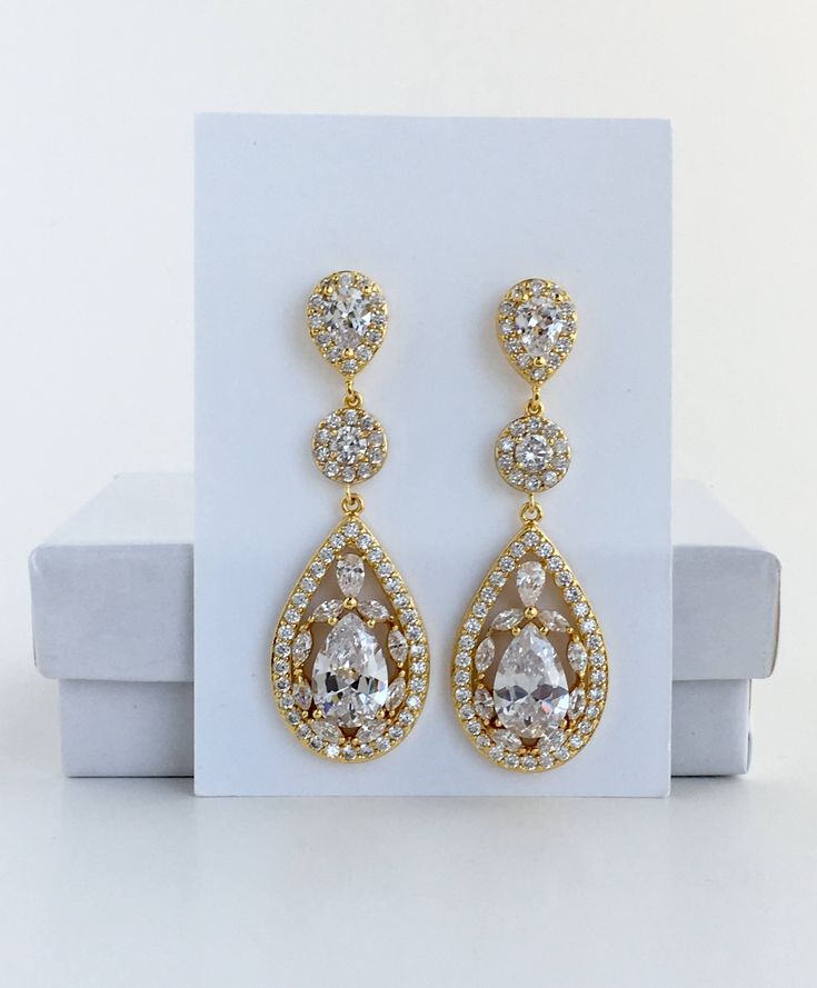 Super sparkly clear cubic zirconia bridal tear drop earrings in gold plated brass setting. I've created these truly amazing earrings with delicately detailed clear cubic zirconia teardrop that dangles from a cubic zirconia detailed halo connector and teardrop ear stud. Total length of the earrings is 5.4 cms. For matching necklace click: https://www.etsy.com/listing/544576302/gold-bridal-necklace-gold-crystal?ref=shop_home_active_1 To browse my collection click : https://www.etsy.com/shops/fanta Gold Drop Chandelier Earrings For Anniversary, Gold Pear-shaped Cubic Zirconia Bridal Earrings, Gold Cubic Zirconia Bridal Earrings, Gold Cubic Zirconia Crystal Earrings For Wedding, Gold Cubic Zirconia Teardrop Earrings For Wedding, Glamorous Gold Drop Bridal Earrings, Gold Pear-shaped Bridal Earrings For Wedding, Wedding Gold Plated Teardrop Chandelier Earrings, Gold Cubic Zirconia Dangle Bridal Earrings