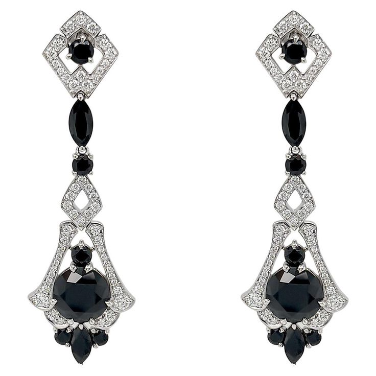 These exquisite earrings are crafted with meticulous attention to detail, inspired by the glamour and precision characteristic of the Art Deco era. At the heart of these earrings lie the captivating black spinels, each boasting a generous 4.70 carats. Surrounding the central spinels are an array of additional spinel gemstones, totaling an impressive 7.28 carats. Enhancing the elegance of these earrings are the shimmering F/G colored natural diamonds, totaling .79 carats. Set delicately in 18k white gold, these diamonds accentuate the overall brilliance of the design, creating a remarkable contrast against the darker gemstones. The intricate detailing and meticulous craftsmanship of these art deco-inspired earrings set them apart as a timeless piece of jewelry. These earrings also have a ma Black Diamond Earrings, Spinel Gemstone, Black Spinel, Matching Rings, Art Deco Era, Art Deco Inspired, Inspiration Art, Black Diamond, Timeless Pieces