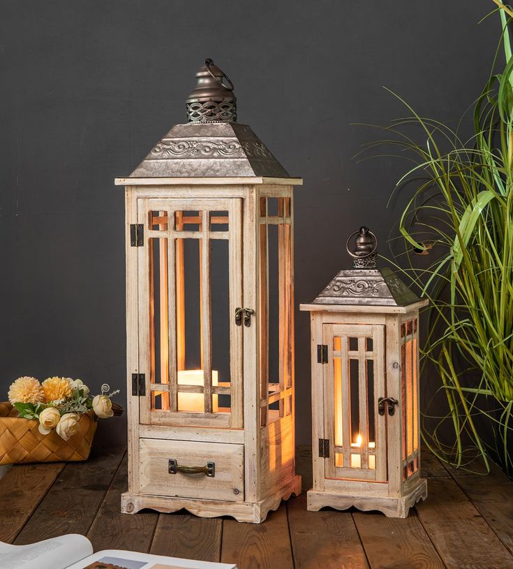 two wooden lanterns sitting on top of a wooden table