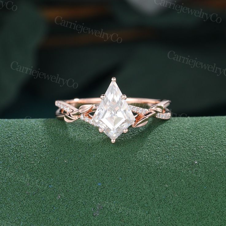 an engagement ring with a princess cut diamond in the center on top of a green surface