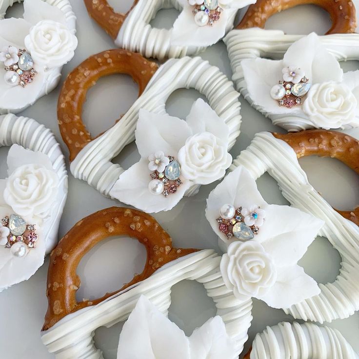 some pretzels are decorated with white flowers and crystal brooches on them