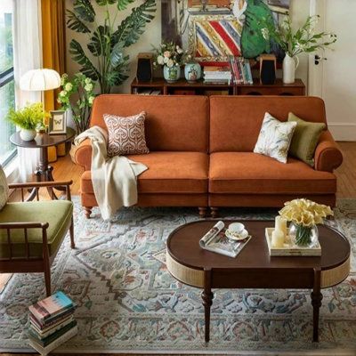 a living room filled with furniture and lots of plants on top of the table in front of it