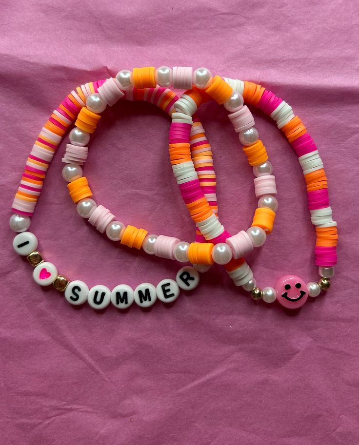 A three pack of bracelets that are pink orange and white Trendy Orange Beaded Bracelets With Letter Beads, Trendy Orange Friendship Bracelets For Beach, Fun Pink Beaded Bracelets For Summer, Trendy Orange Friendship Bracelets With Colorful Beads, Cute White Bracelets For Summer, Trendy Orange Beaded Bracelets For Friendship, Trendy Orange Beaded Friendship Bracelets, Orange Colorful Beads Friendship Bracelets For Summer, Summer Friendship Bracelets In Orange