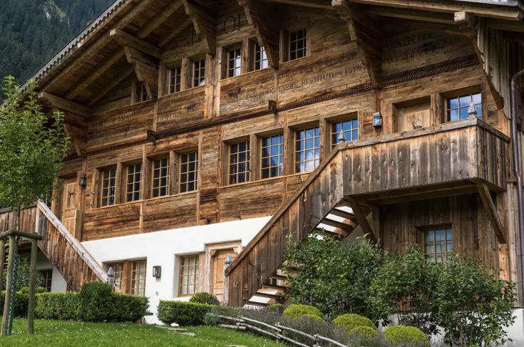 an old wooden house with stairs leading up to the upper floor and second story windows