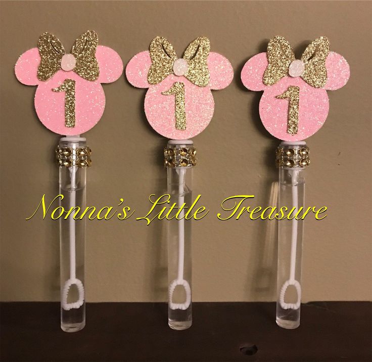 three pink and gold minnie mouse bottle stoppers with glitter bows on each one side