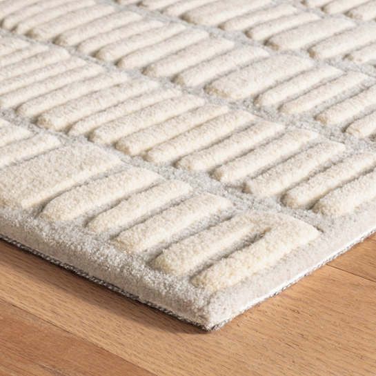 a close up of a rug on a wooden floor with wood floors in the background