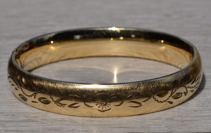 Ladies Floral Engraved Gold Filled Bangle Bracelet.  Measuring 7 inches in length and 7/16 inch in width, this bangle bracelet is in great condition.  The bangle is engraved with flowers across the top and complete with a brushed finish. Love this piece, but don't have the money to spend right now?  We offer FREE layaway on every item in our shop.  With just 20% down, take one full year (interest-free) to pay off your new jewelry!  There are no hidden fees or charges, ever.  For more information Heirloom Style Engraved Bangle For Formal Occasions, Heirloom Engraved Bangle For Formal Occasions, Elegant Stamped Bangle For Formal Occasions, Antique Etched Bangle For Wedding, Formal Engraved Bangle Cuff Bracelet, Adjustable Engraved Bangle For Formal Occasions, Antique Etched Wedding Bangle, Formal Heirloom Engraved Bangle, Elegant Stamped Bangle Bracelet