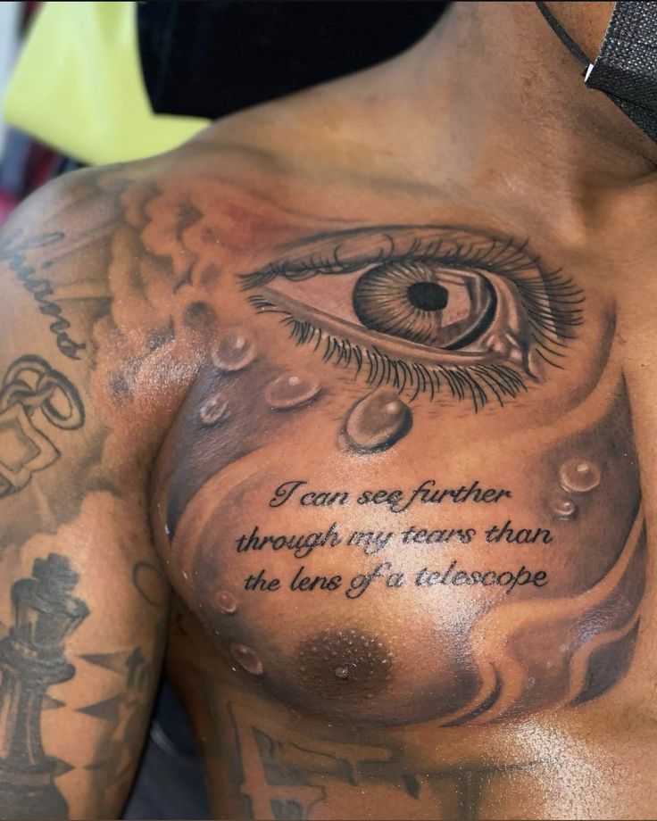 a man's chest with an eye and quote written on the upper half of his body