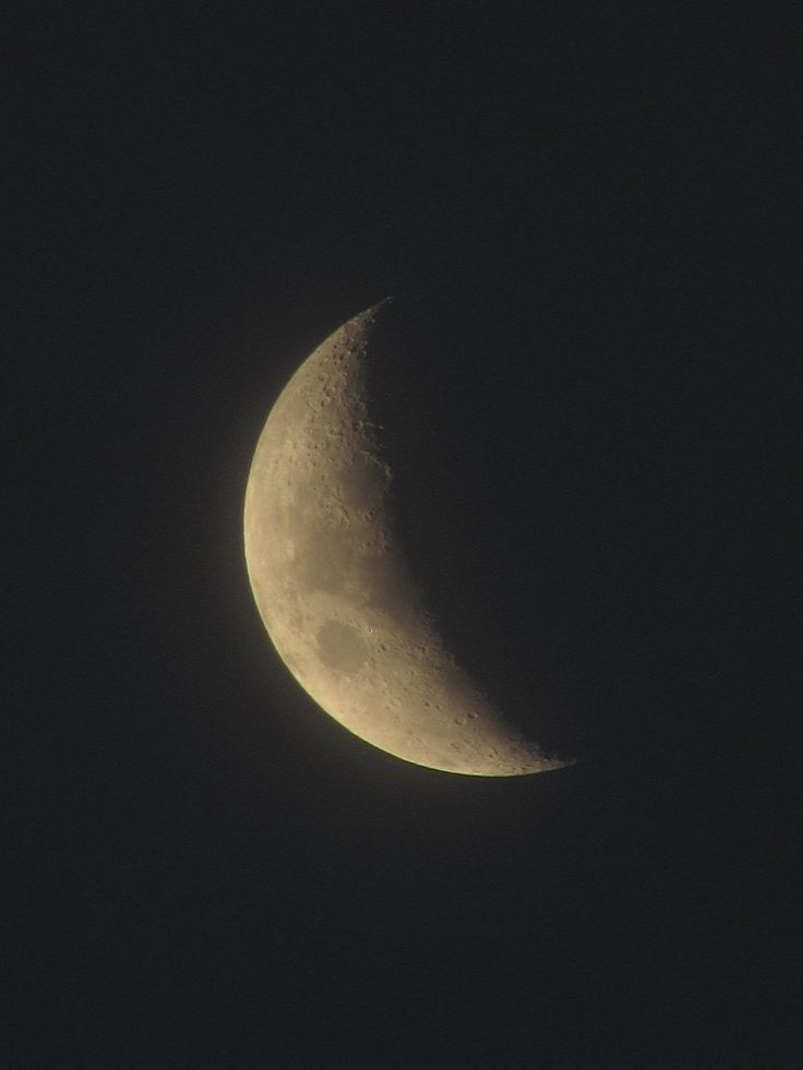 the moon is seen in the dark sky