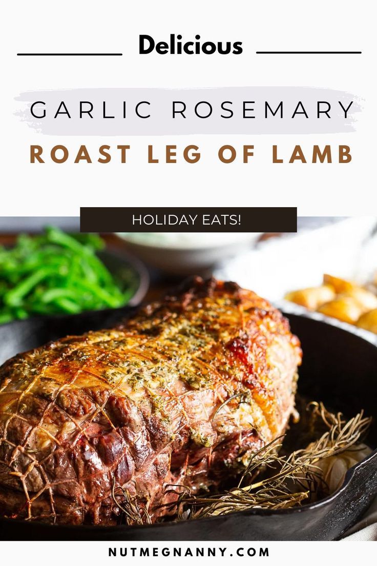 roast leg of lamb in a cast iron skillet with garlic and rosemary garnish