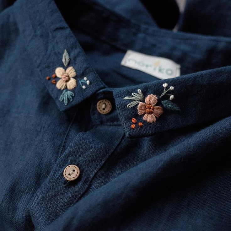 a blue shirt with embroidered flowers on it