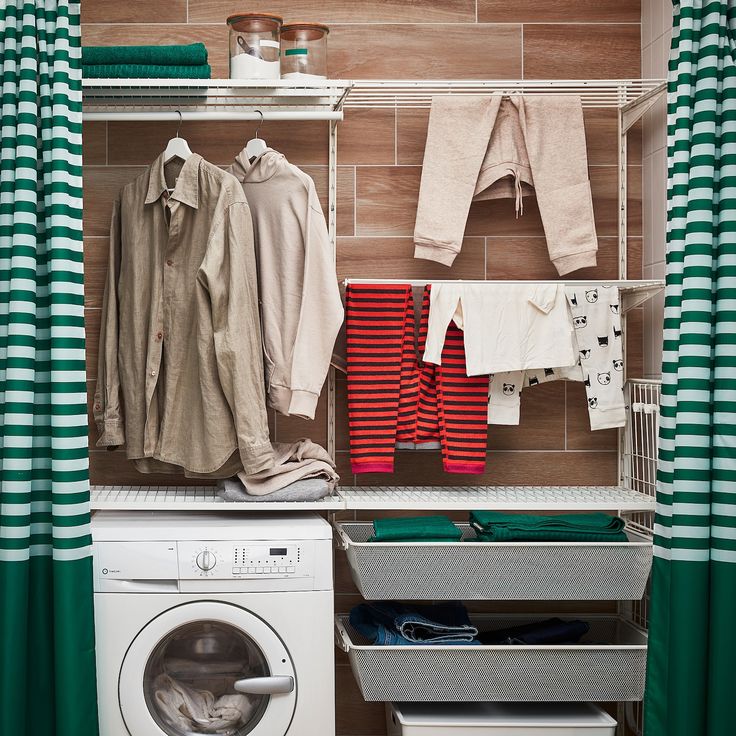 a washer and dryer in a small room with green curtained drapes