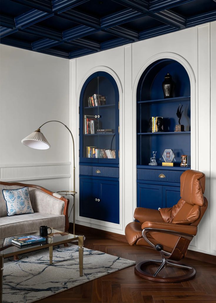 the living room is decorated in blue and white with built - in bookshelves