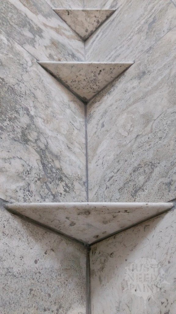 the corner of a white marble wall with four triangulars on it's sides