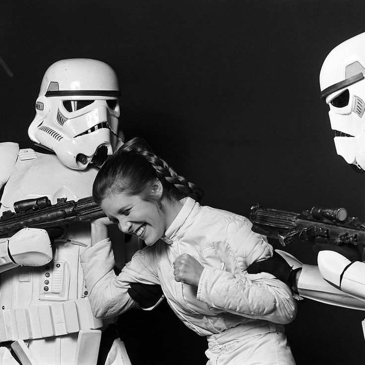 a woman in a star wars costume is posing next to two stormtroopers