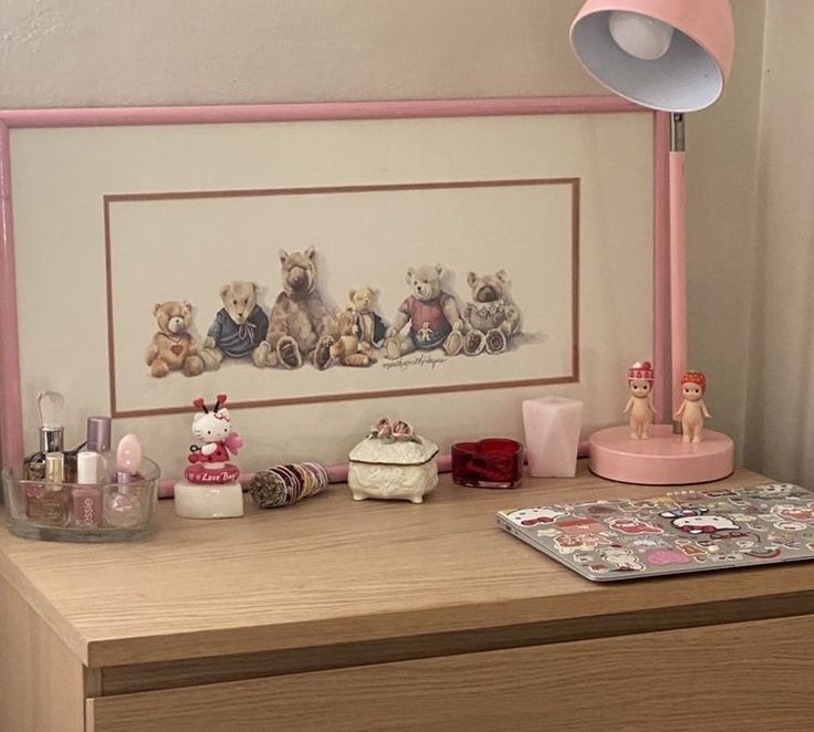 a pink lamp on top of a wooden dresser next to a teddy bear wall hanging