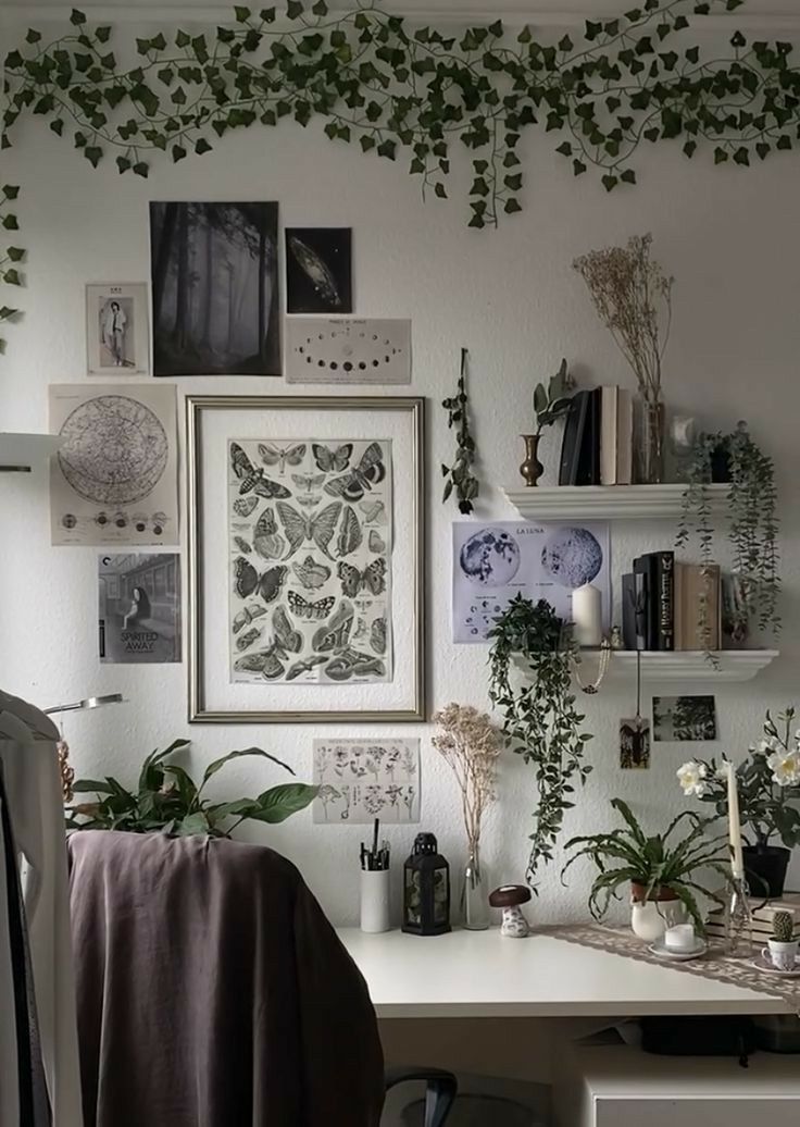 a white desk topped with lots of plants and pictures