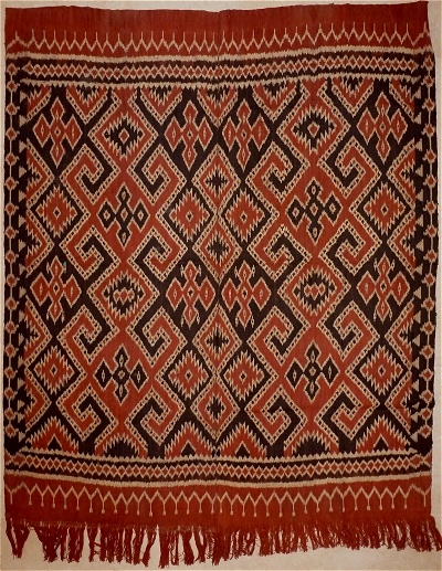 an old red and black rug with fringes