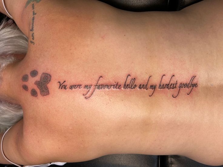 Dog memorial back tattoo Lost A Dog Tattoo, Dog Memorial Tattoos Thigh, Dog Back Tattoo Women, Dog Paw Print Tattoo With Quote, Dog Ashes Tattoo, Puppy Remembrance Tattoos, Tatoos To Remember Your Dog, Memorial Back Tattoos Women, Rest In Peace Dog Tattoo