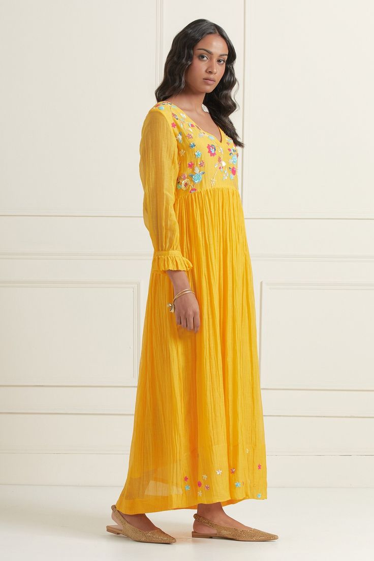 Yellow chaderi fit and flare dress with sequin floral embroidered motifs.
Component: 1
Pattern: Embroidered
Type Of Work: Floral
Neckline: V-Neck
Sleeve Type: Puff
Fabric: Chanderi
Color: Yellow
Other Details: 
Hand embroidered front and back yoke
Pleated sleeve detail
Occasion: Resort,Party - Aza Fashions Festive V-neck Dress With Resham Embroidery, Navratri Embroidered Straight Kurta Dress, Semi-stitched Anarkali Dress With Floral Embroidery, Yellow Chanderi Dress With Mirror Work, Embellished Semi-stitched Chanderi Dress, Spring Festive Anarkali Maxi Dress, Maxi Length Dress With Chikankari Embroidery For Navratri, Designer V-neck Dresses With Zari Work, Navratri Maxi Dress With Chikankari Embroidery