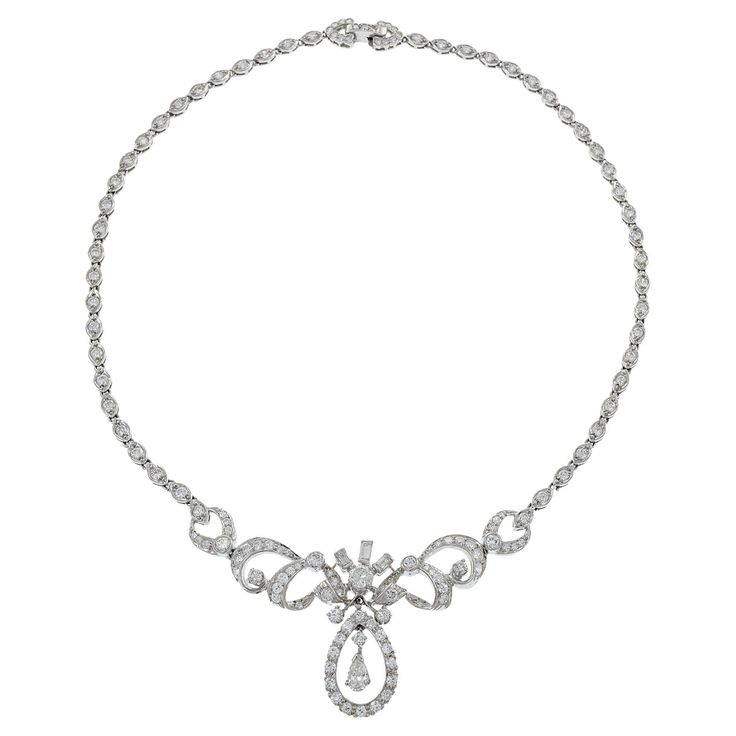 This exquisite estate necklace from the Art Nouveau era, weighing 31.93 grams, is crafted in platinum and features an elegant drop design. The necklace showcases a total of 6.00 carats of diamonds, including round and pear cut stones with G-J color and VS/SI clarity. This luxurious piece embodies the graceful and artistic style of the Art Nouveau period, making it a timeless addition to any jewelry collection. Exquisite Pear-shaped Diamond Necklace For Formal Events, Exquisite Pear-shaped Diamond Necklace For Formal Occasions, Platinum Necklaces With Diamond Accents, Pear-shaped, Formal Briolette Diamond Necklace With Brilliant Cut, Formal Briolette Brilliant Cut Diamond Necklace, Silver Platinum Pear-shaped Necklace, Pear-shaped Platinum Silver Necklace, Formal Silver Pear-shaped Diamond Necklace, Elegant Briolette Diamond Necklace For Formal Occasions