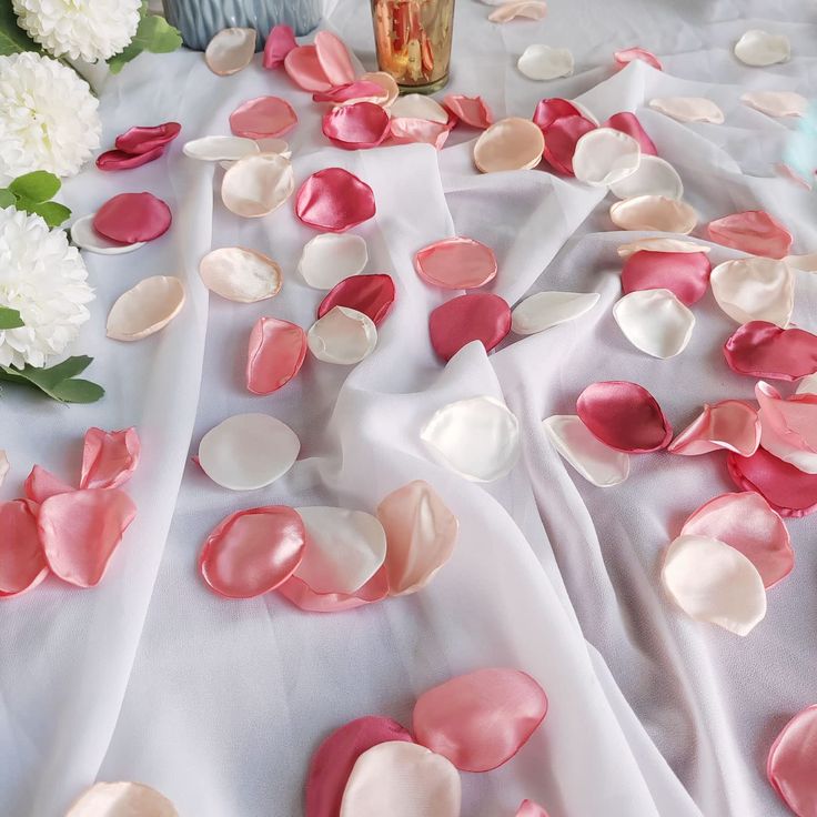 pink and white petals are scattered on the table