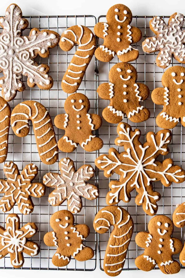 a cooling rack filled with lots of different kinds of gingerbreads on top of a white table